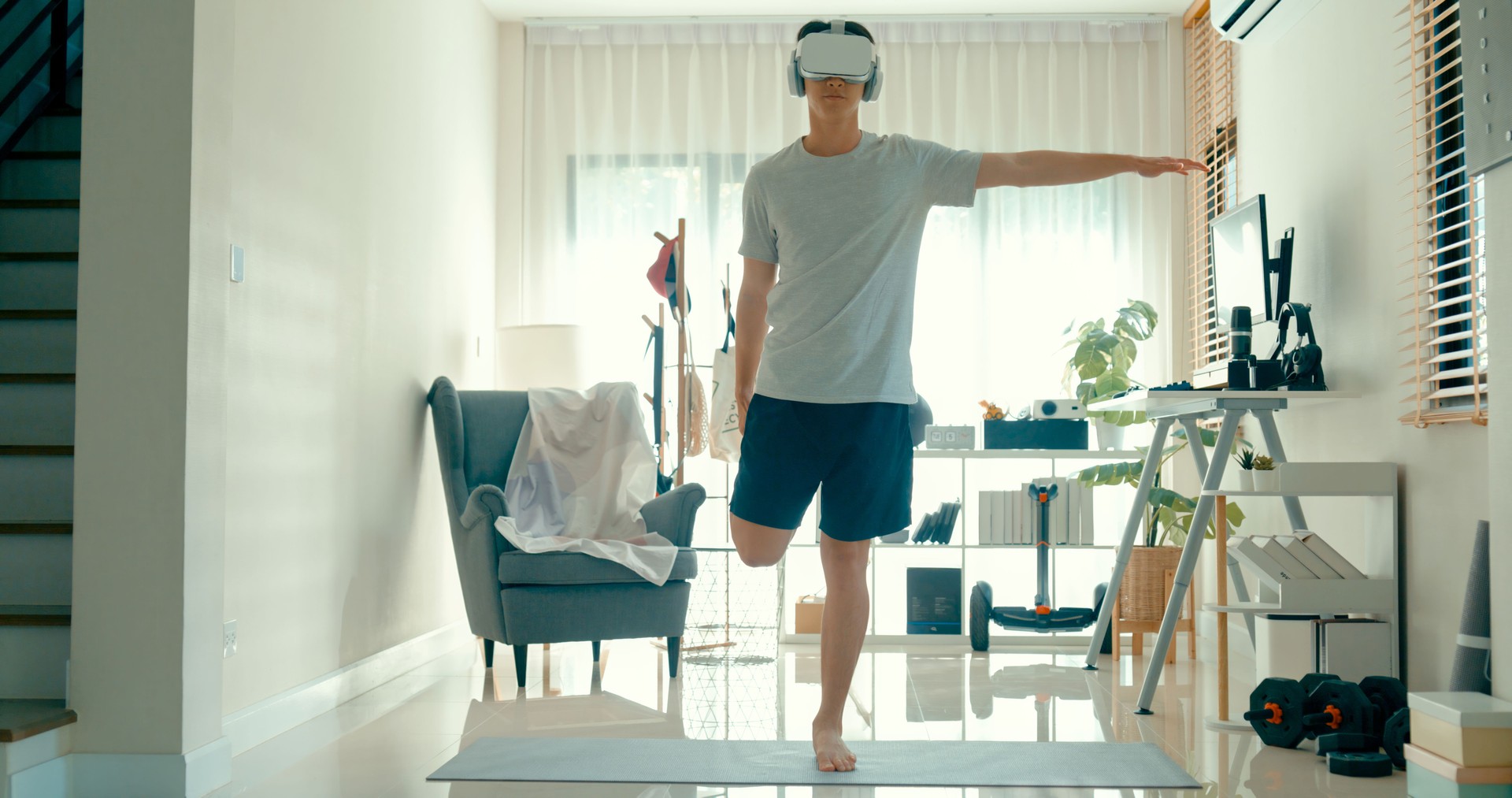 Young Asian athletic man squat position enhances workout routine with virtual reality headset, blending physical exercise with digital tech at home. Diet and exercise morning routine.